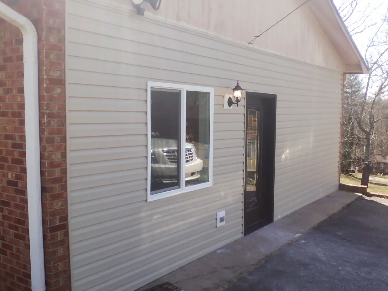 New vinyl siding and entry door on a room addition in Little Switzerland
