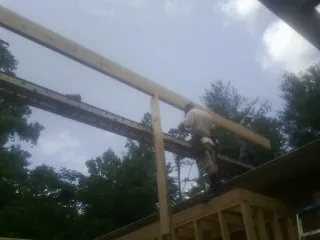 Carpenter setting a ridge beam over a new addition frame — Ice Dam Removal by Roofing Brothers in Little Switzerland