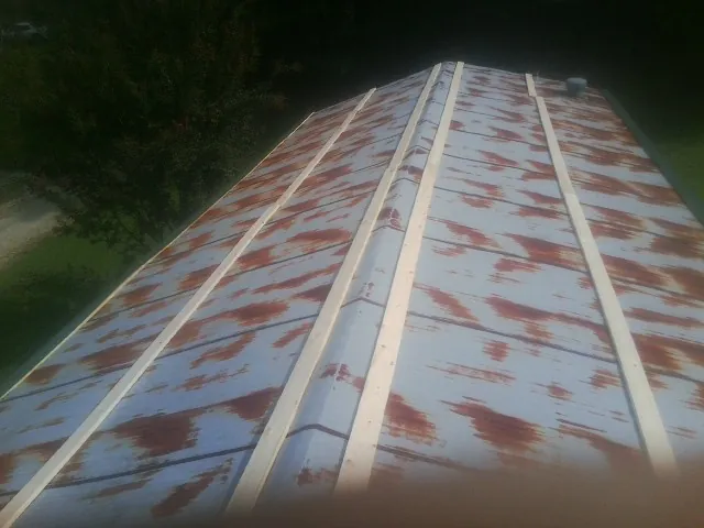 Rusted metal roof panels with new wood purlins before replacement — Storm Damage Roof Repair in Little Switzerland by Roofing Brothers
