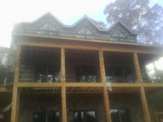 Dormers and porch framing on a large log home under construction — Roof Coating work by our crew in Little Switzerland