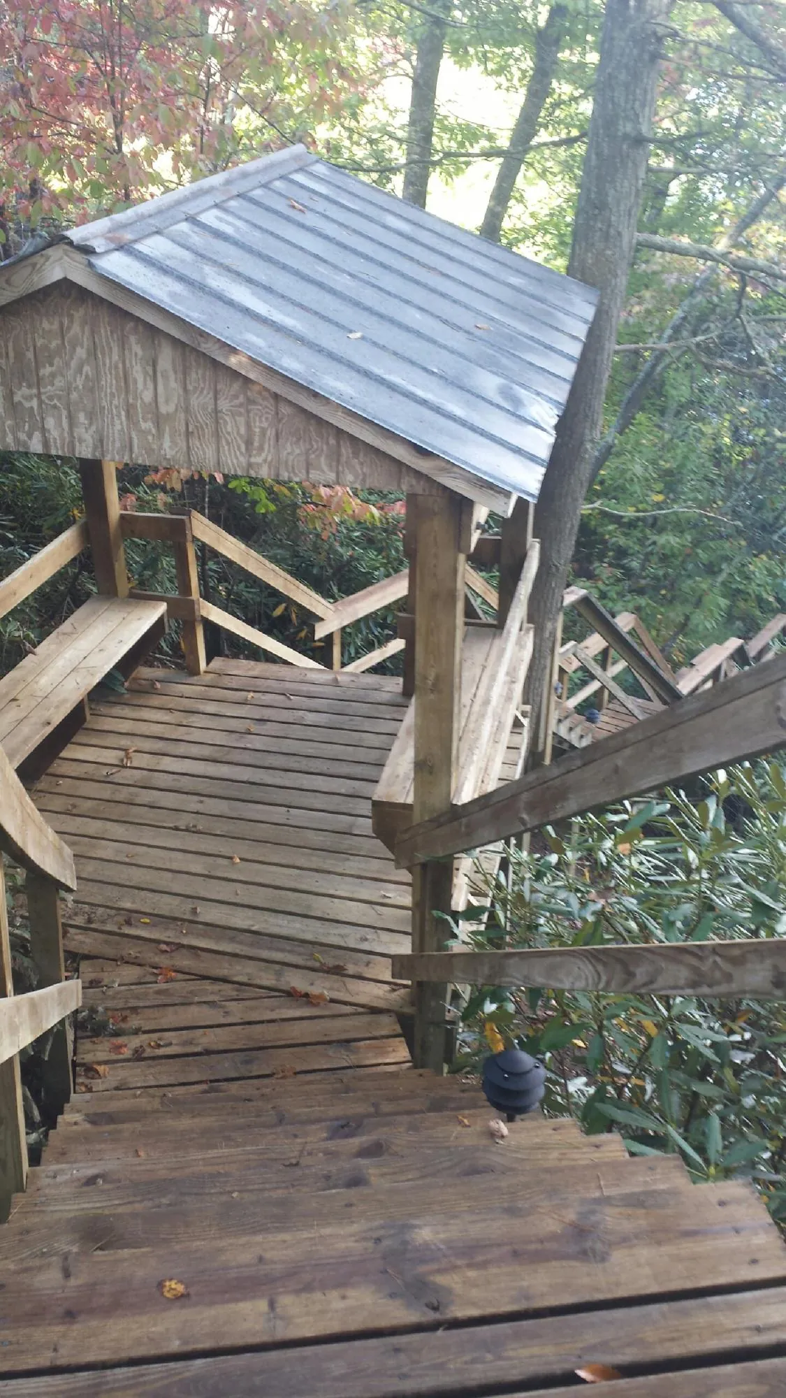 Metal roofed shelter over wooden steps on a wooded walkway — Skylight Repair & Installation work by our crew in Little Switzerland