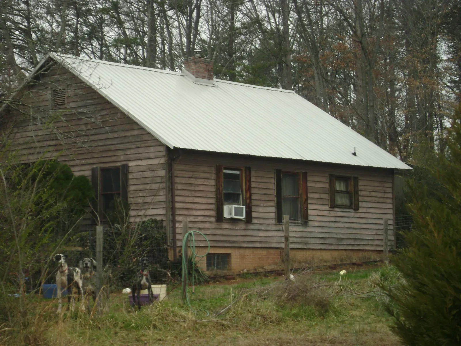 White metal roof on an old wood sided farmhouse, from a Metal Roof Installation job in Little Switzerland